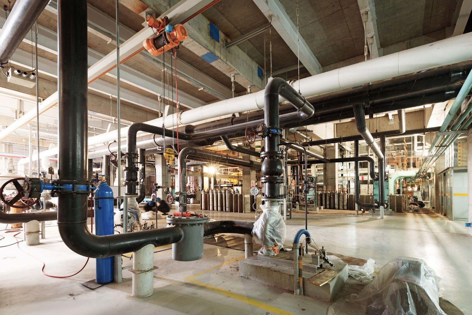 A network of pipes running through a large industrial building showcasing the complexity of its infrastructure
