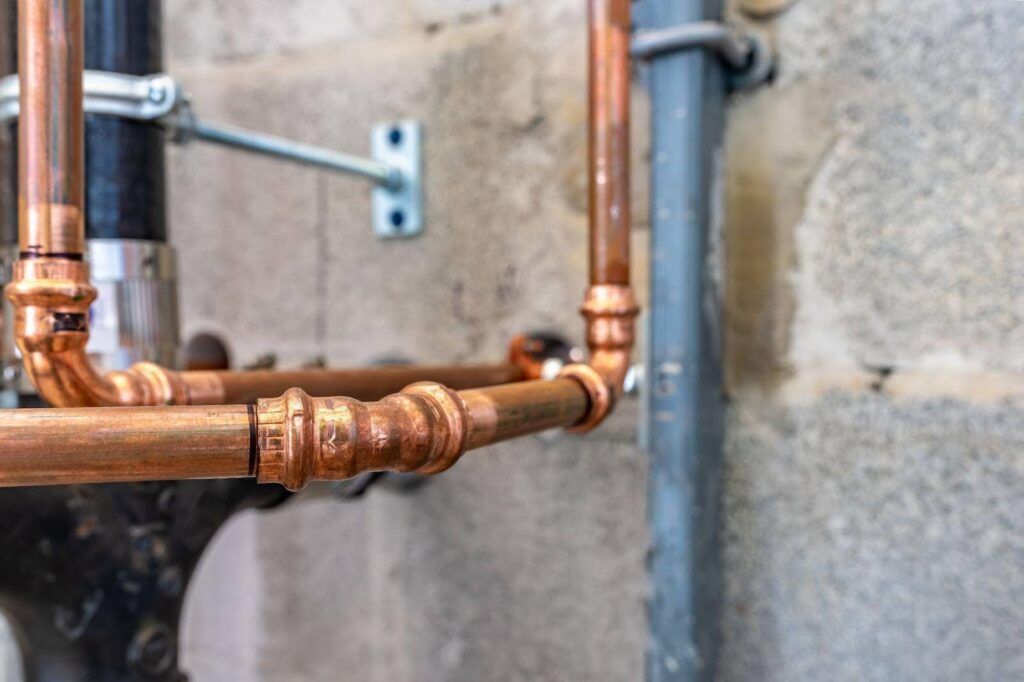 Close-up of copper plumbing pipes and valves emphasizing their design and functionality in a mechanical setup